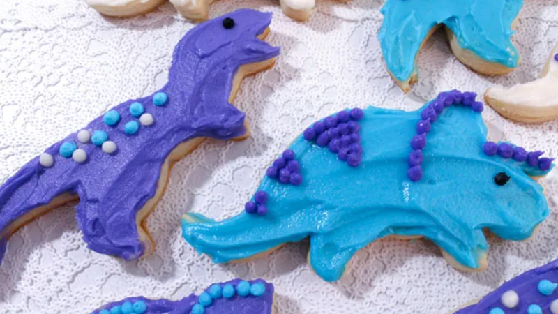 sugar cookies shaped and decorated to look like dinosaurs